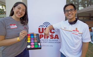 APIFSA member paint USC logos on hands at tailgate event